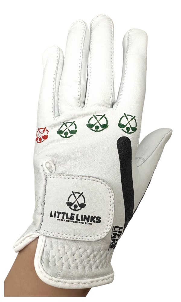 Little Links kids golf training glove in white shown in a front view on a child’s hand, featuring visual grip guides and logo details designed to help young golfers learn proper hand placement and build confidence from their very first swings.